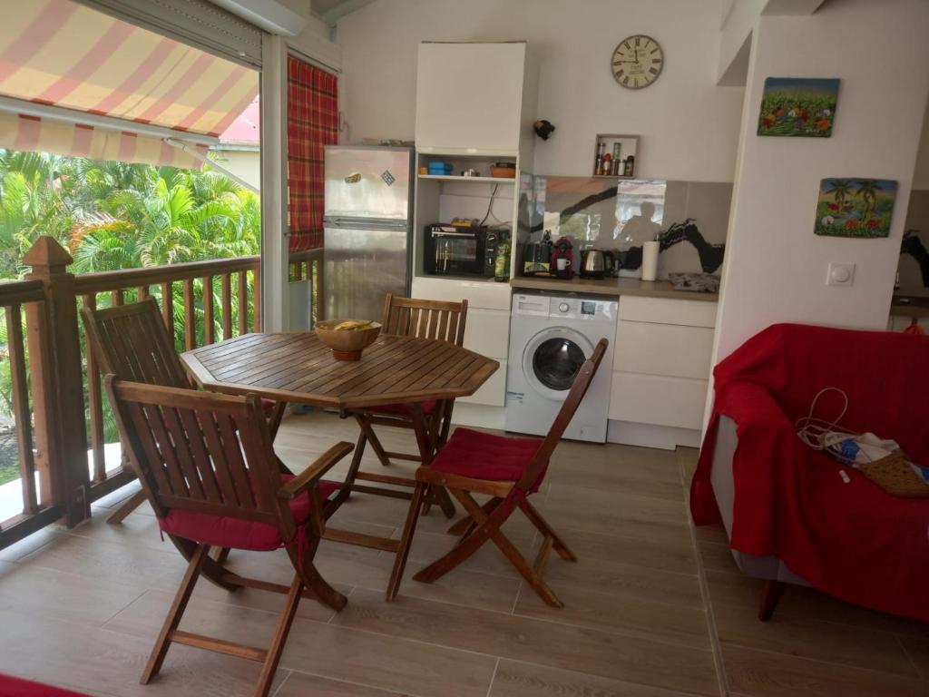 une cuisine avec une table et des chaises en bois dans une pièce dans l'établissement Pa ni problème, à Saint-François