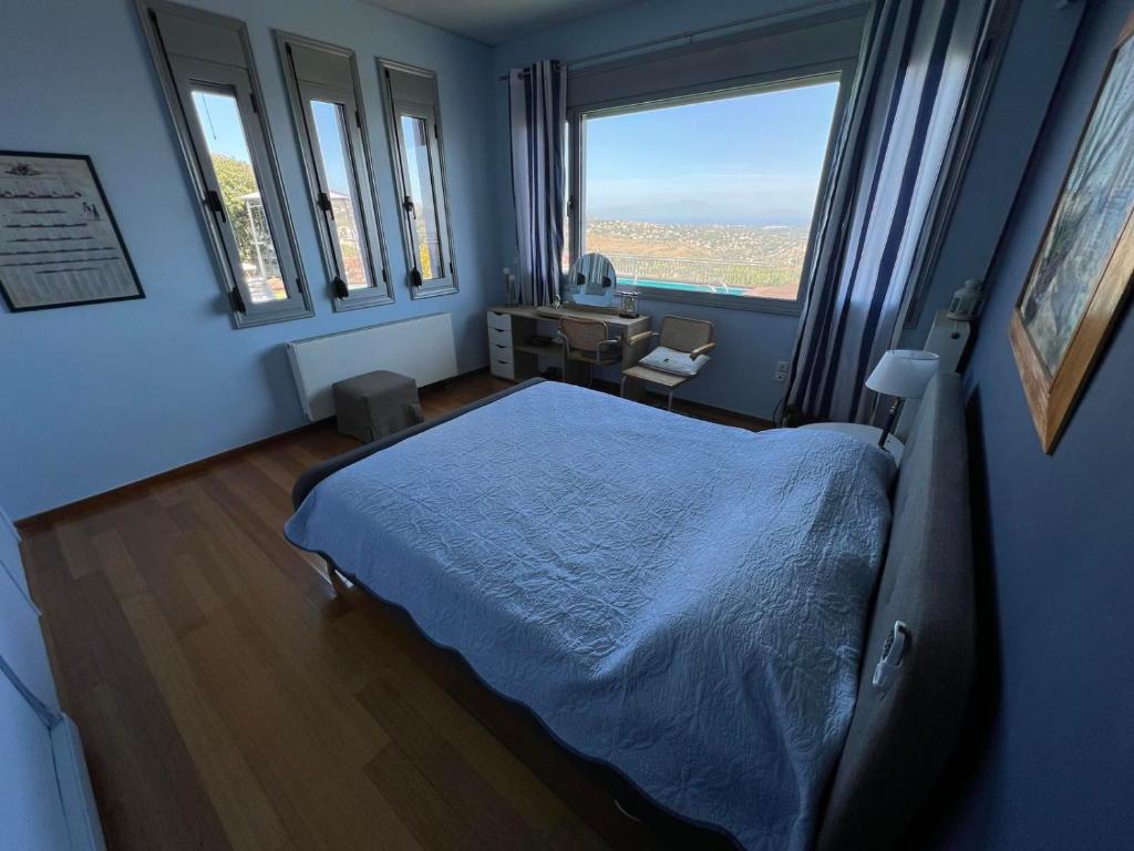 1 dormitorio con 1 cama, escritorio y ventanas en Reunion in Greece Villa, en Drafí
