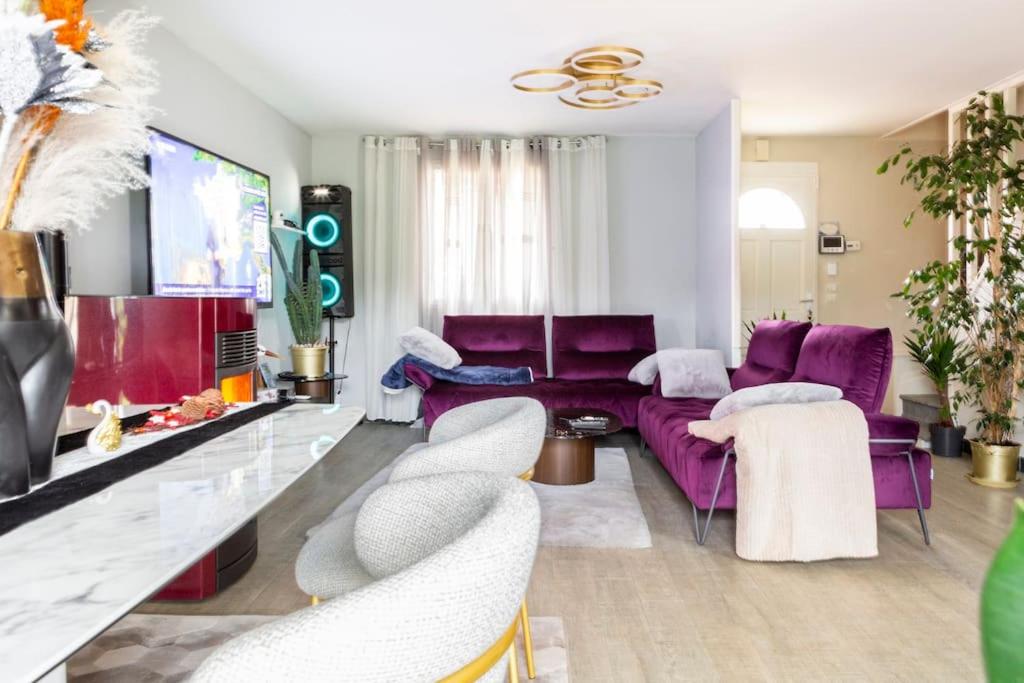 a living room with purple furniture and a purple couch at Maison romantique entre deux fleuves chez l'habitant in Montereau-Fault-Yonne