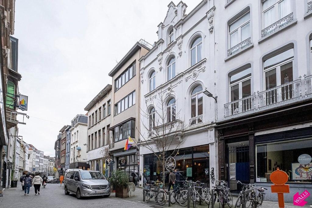 una via cittadina con edifici e un'auto e biciclette di Unique Mansion RL ad Anversa