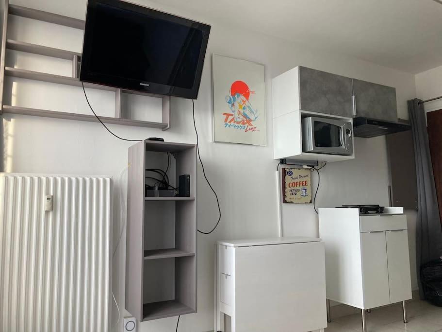 un salon avec une télévision au mur dans l'établissement Studio Tout équipé Evreux, à Évreux