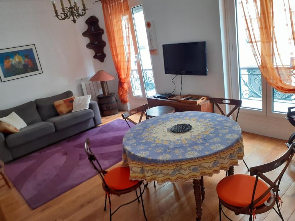 Appartement Petroff في باريس: غرفة معيشة مع طاولة وأريكة