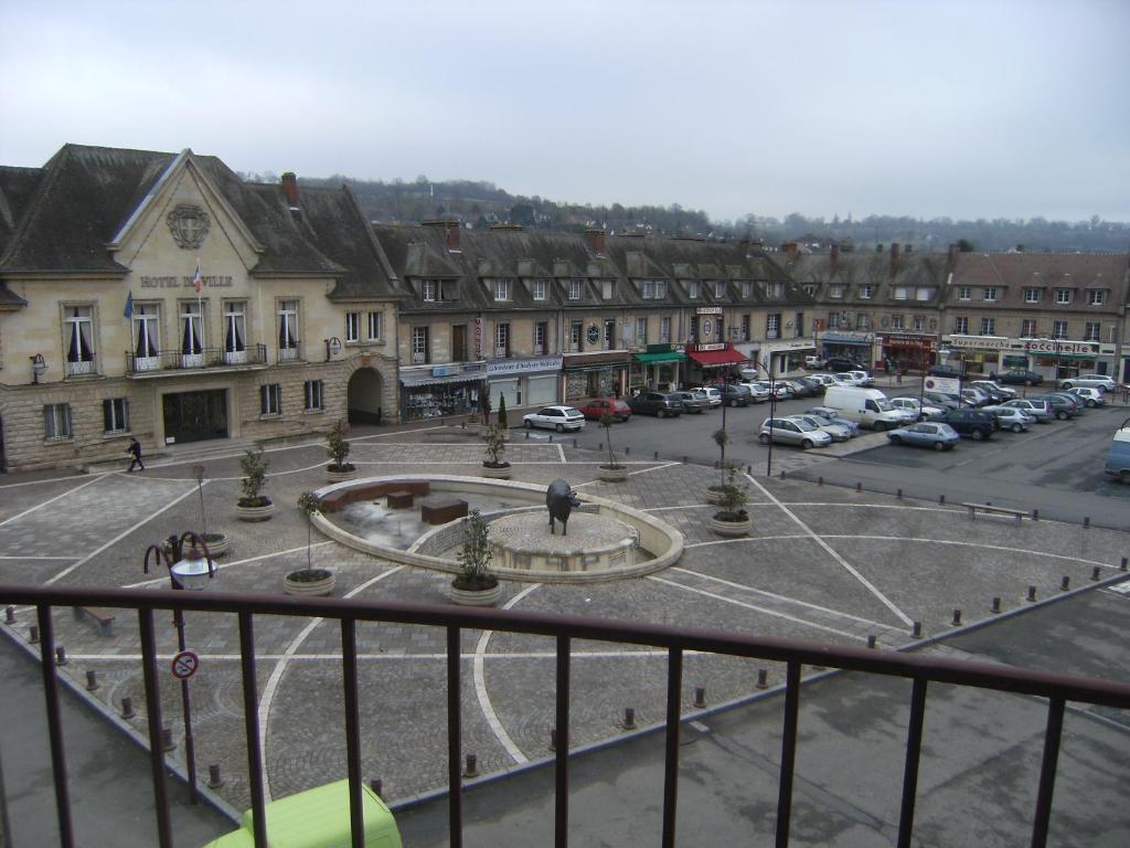 a view of a town with cars parked in a parking lot at Le Soleil D'or in Vimoutiers