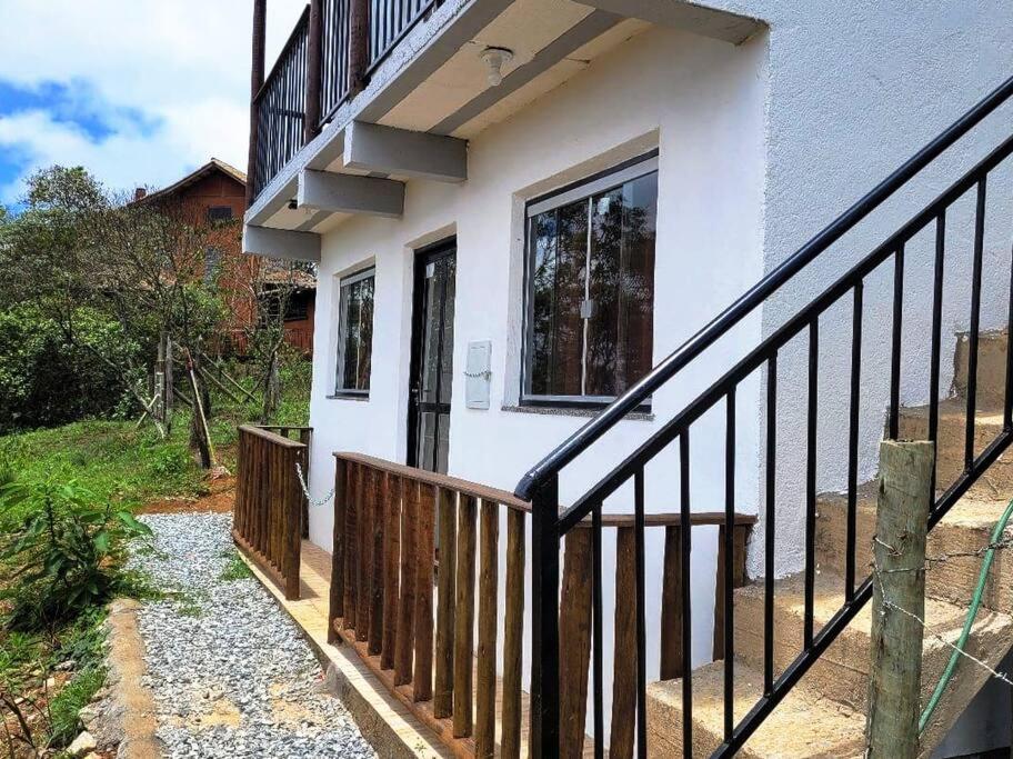 a house with a wooden railing and a balcony at Casa em Lavras Novas in Ouro Preto