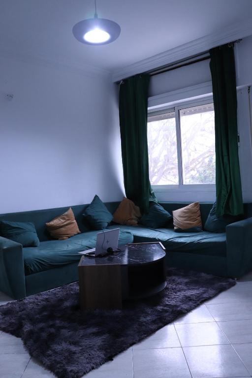 een woonkamer met een blauwe bank en een raam bij YOUR HOUSE in Rabat