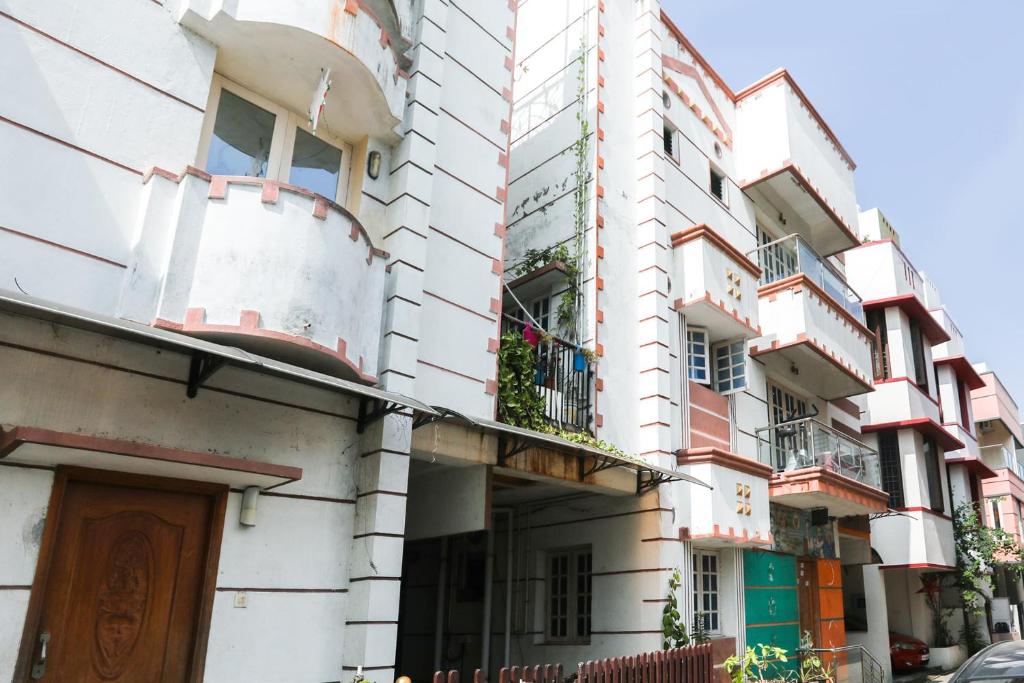 - un bâtiment blanc avec balcon dans une rue dans l'établissement OYO Flagship Maheshwari Villas, à Chennai