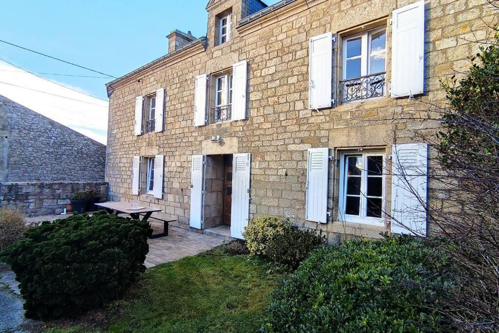 une maison en briques avec un banc devant elle dans l'établissement Gîte Ty Maen à Plouhinec 56 4pers, à Plouhinec