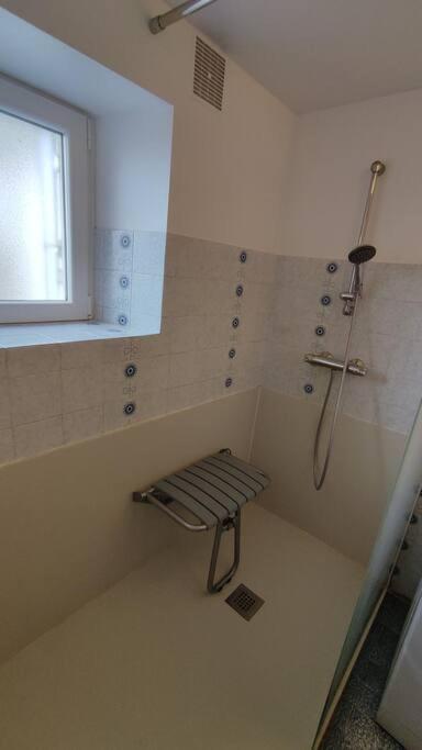 a bathroom with a shower and a bench in it at Gîte Ty Maen à Plouhinec (56) 4 in Plouhinec