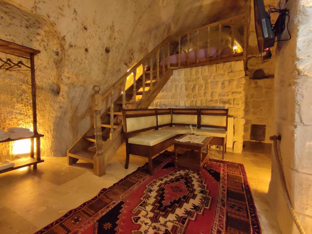 Habitación con escalera, banco y alfombra. en Euphoria Cave House en Nar