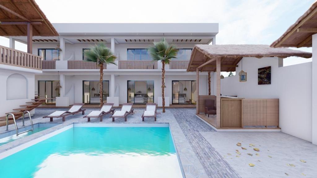 een villa met een zwembad en palmbomen bij adma hotel in Paje
