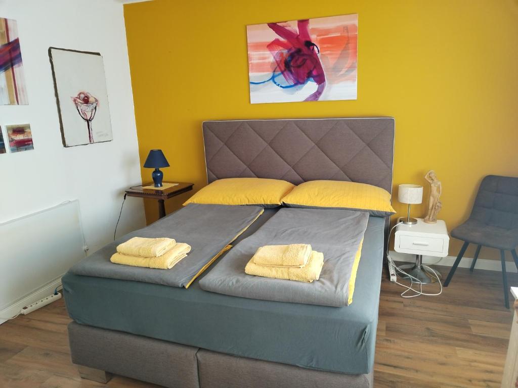 - une chambre avec un lit et 2 oreillers jaunes dans l'établissement Waldeslust Villach Warmbad, à Villach