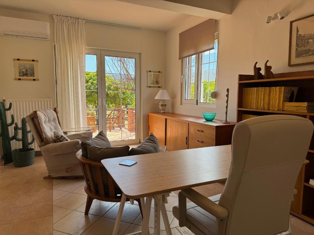 een woonkamer met een houten tafel en stoelen bij Primavera Retreat in Chania
