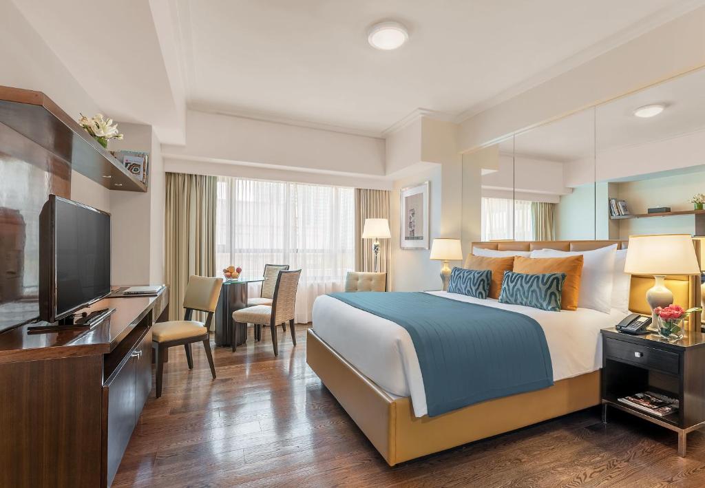 una camera d'albergo con letto e TV di Aruga Apartments by Rockwell Makati a Manila