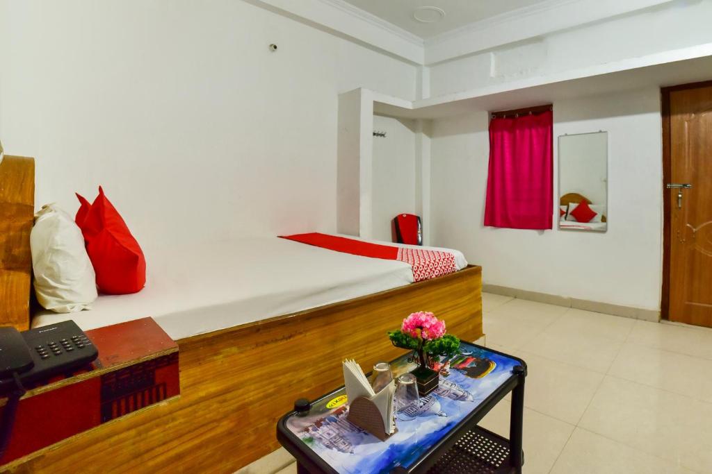 a bedroom with a bed and a desk with a laptop at OYO Flagship Mamta Hotel in Hājīpur