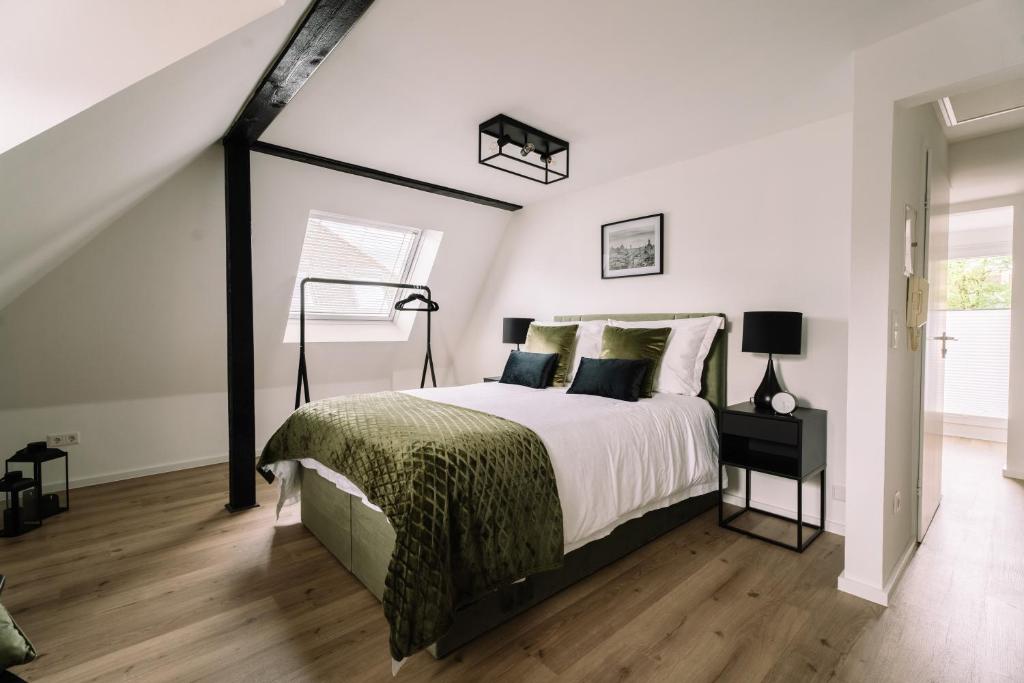 a bedroom with a large bed and a staircase at Green Flat Düsseldorf 2.0 in Düsseldorf