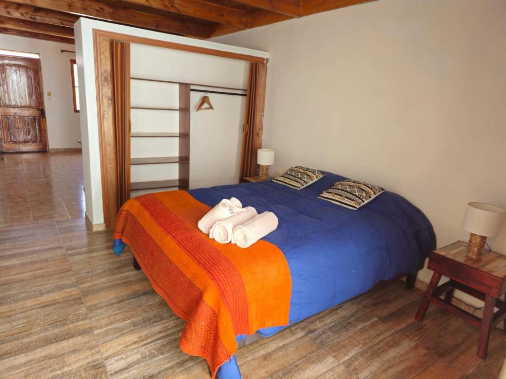 a bedroom with a blue bed with towels on it at Hostal Belen in San Pedro de Atacama