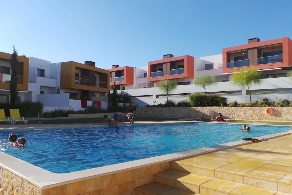 una piscina di fronte a un edificio con persone di Luxury apartment in Vitismar condo view sea & pool a Galé