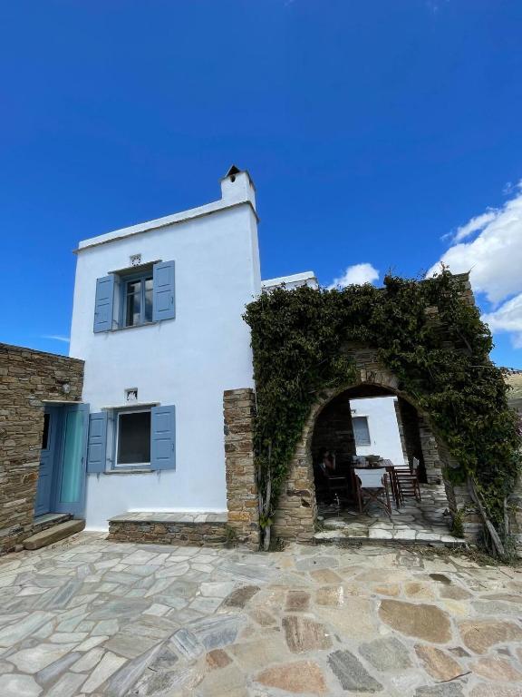 a white building with an arch in front of it at Nightsky Tinos Villa w Unrestricted View in Tripótamos