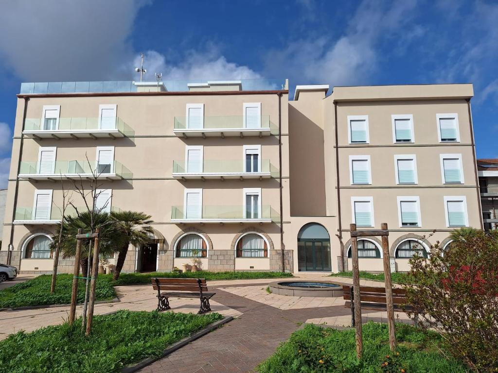 a large building with a bench in front of it at Hotel Villa Delle Rose in Oristano