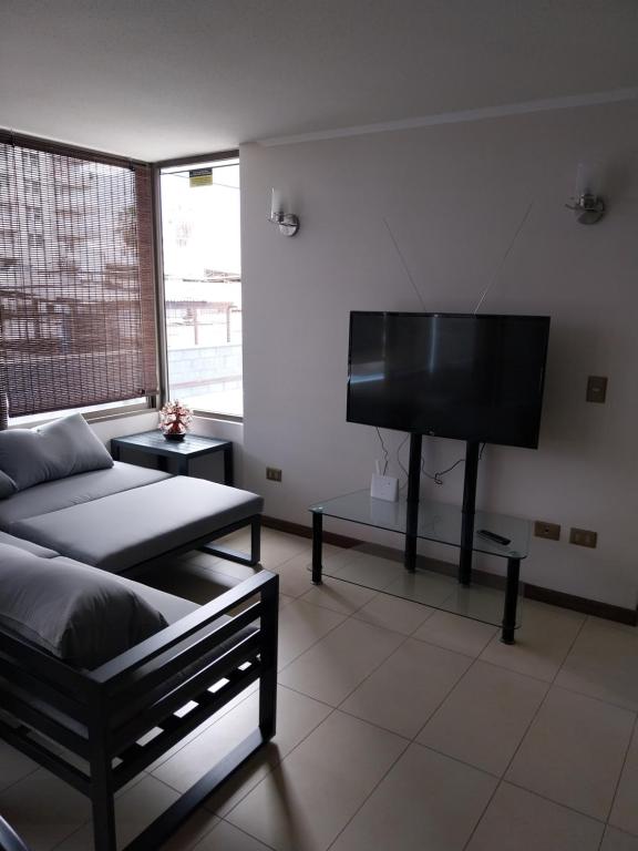 sala de estar con cama y piano en Azul 1 en Iquique