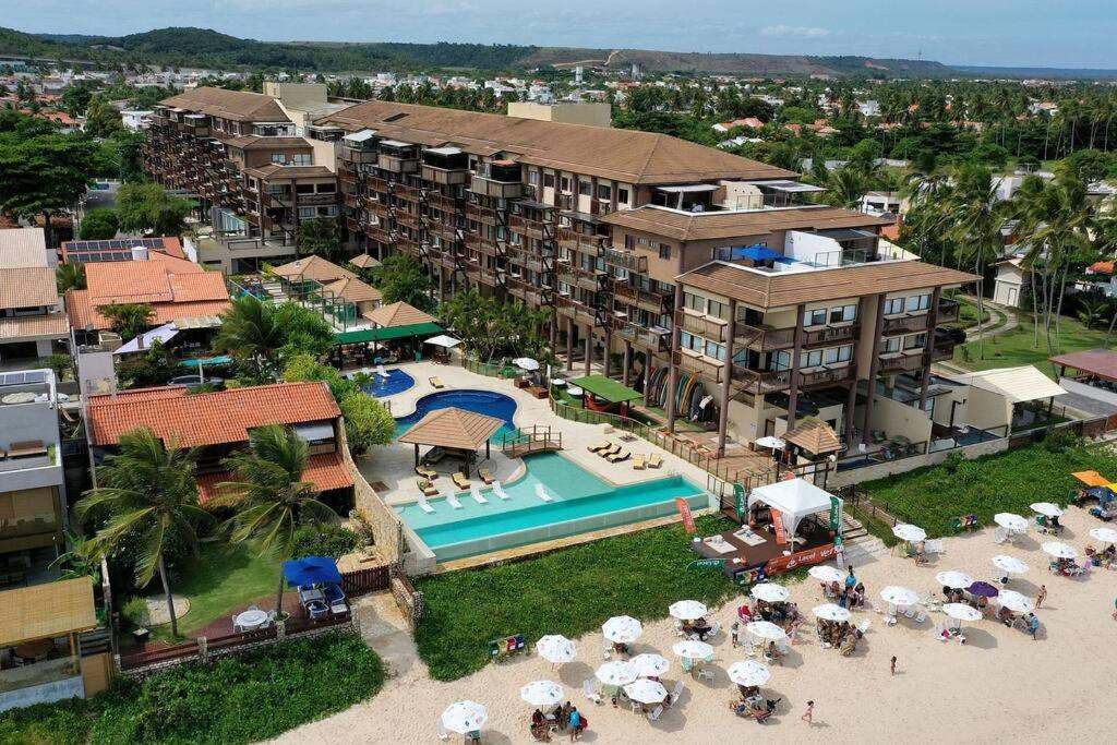 an aerial view of a resort with a swimming pool at Beira-Mar 4 Suítes/ piscina / churrasqueira /campo in Barra de São Miguel