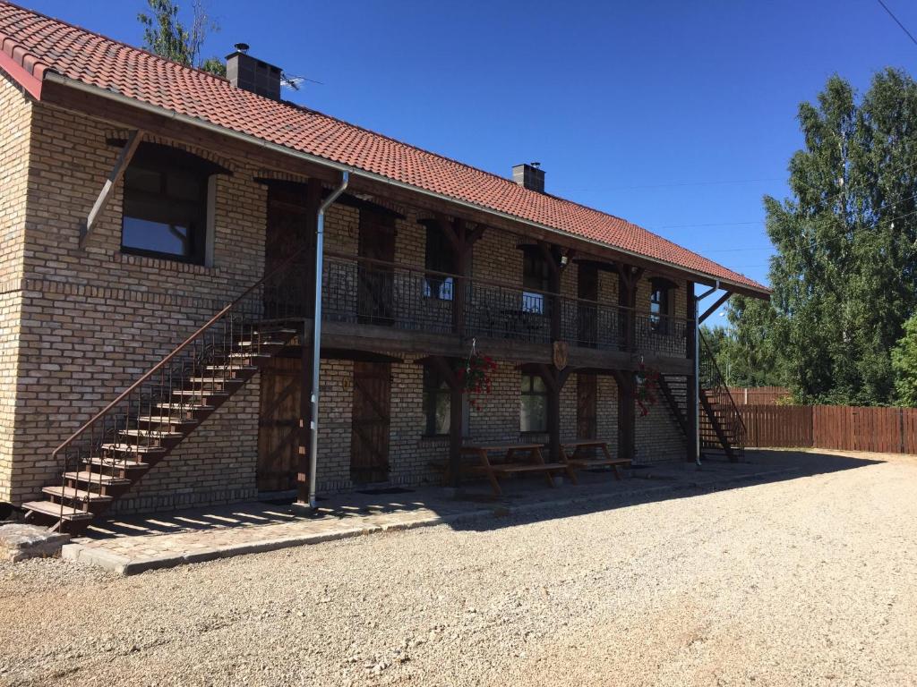 a brick building with a staircase on the side of it at Cērpas in Medemciems