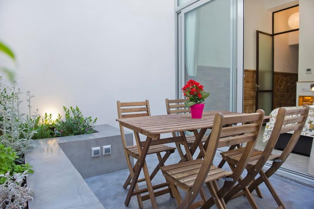 einen Holztisch und Stühle mit einer Vase aus Blumen auf einer Terrasse in der Unterkunft Architects Home By MyRentalHost in Barcelona