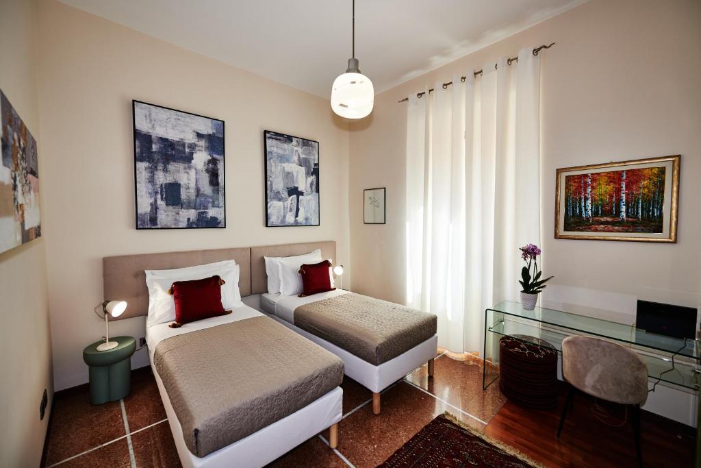 a bedroom with two beds and a desk in it at Vatican Prestige - Meospiti Cesare Exclusive in Rome