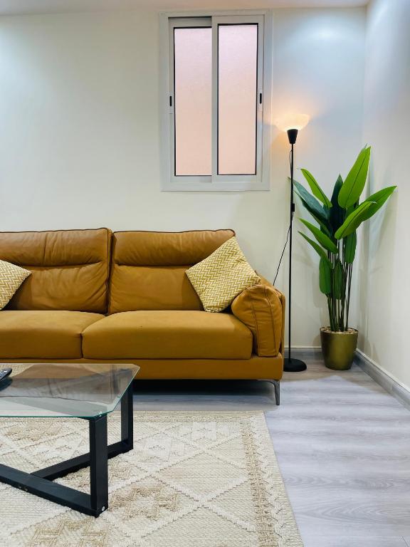 ein Wohnzimmer mit einem braunen Sofa und einem Fenster in der Unterkunft ماكس الفندقية ٣١ in Riad