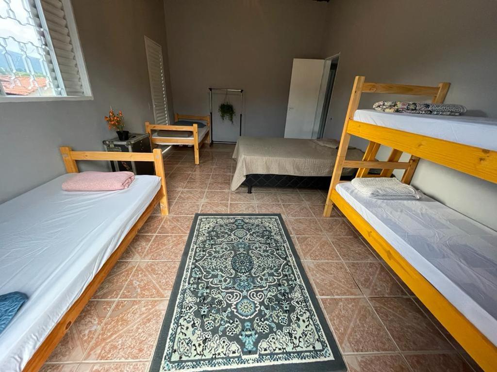 a room with three bunk beds and a table at Hostel do Cerrado in Cavalcante
