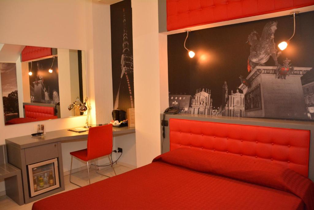 Dormitorio rojo con escritorio y cama roja en Hotel Villa Glicini, en Pinerolo