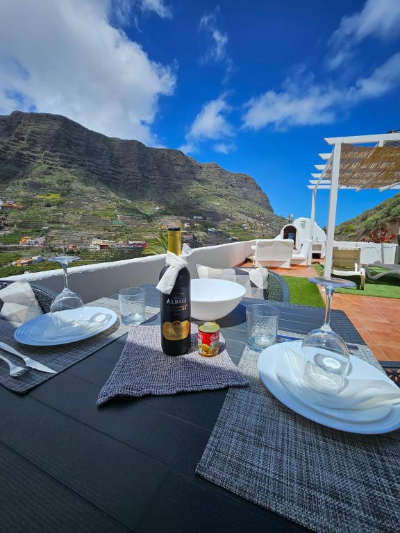 - une table avec des assiettes et des verres à vin sur la terrasse dans l'établissement Casa Lara, à Hermigua