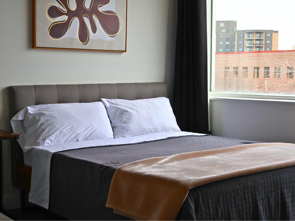 1 cama en un dormitorio con ventana en Logîtel Rimouski en Rimouski