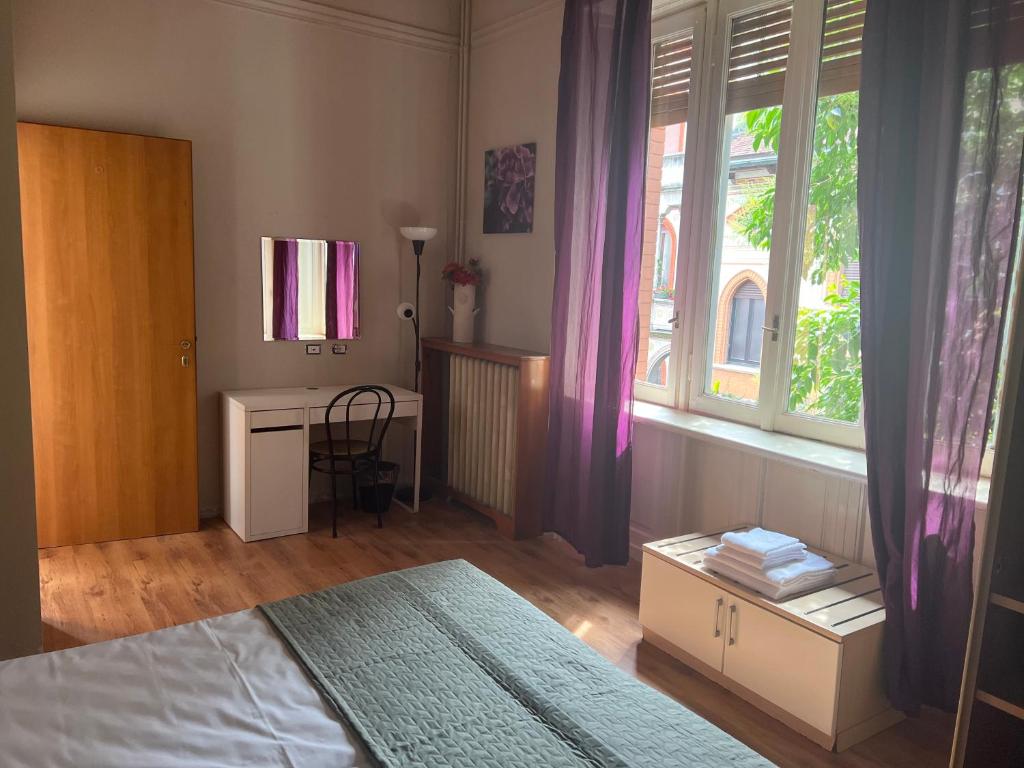 a bedroom with a bed and a desk and a window at Ambra Boutique Hotel in Milan