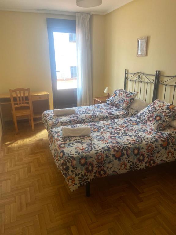 - une chambre avec 2 lits et une fenêtre dans l'établissement Apartamento Isabela3, à Cangas de Onís