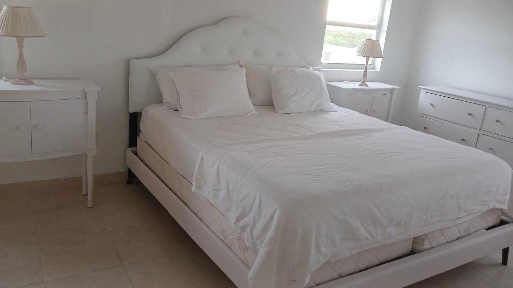 Wheeland SettlementNew condo with sea view (unit 3 of 3)的卧室内的白色床、白色床单和枕头