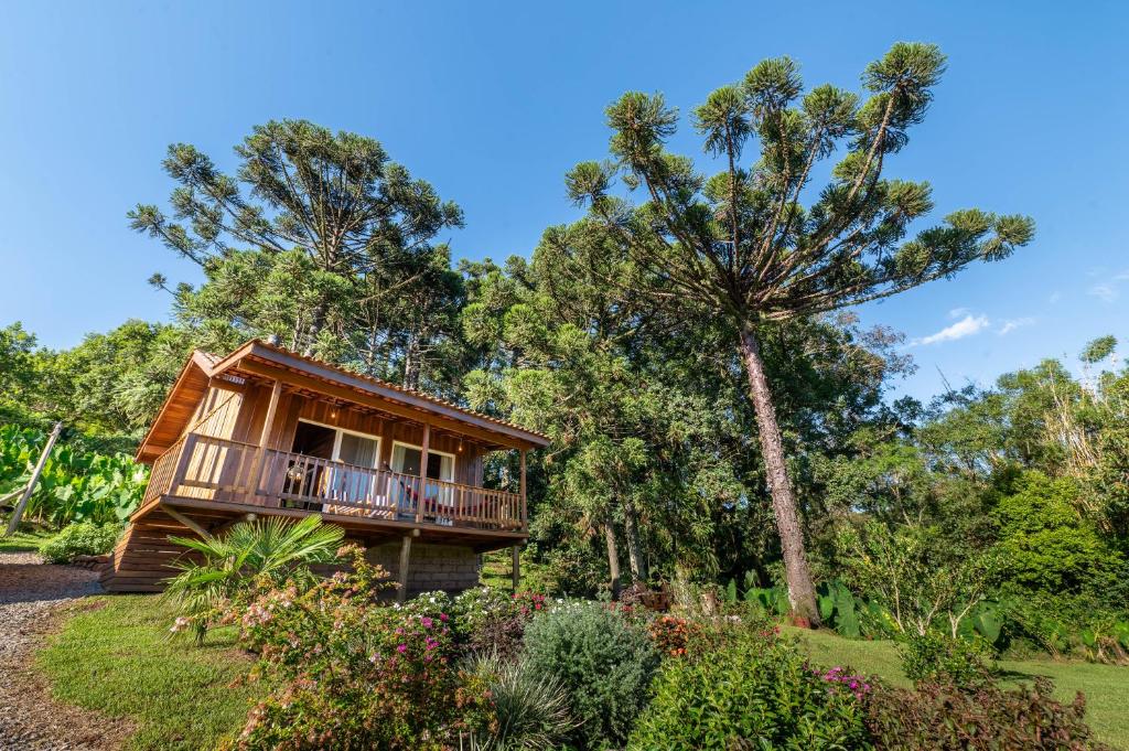 a cabin in the woods with a deck and trees at Cabanas da Fazenda in Gramado