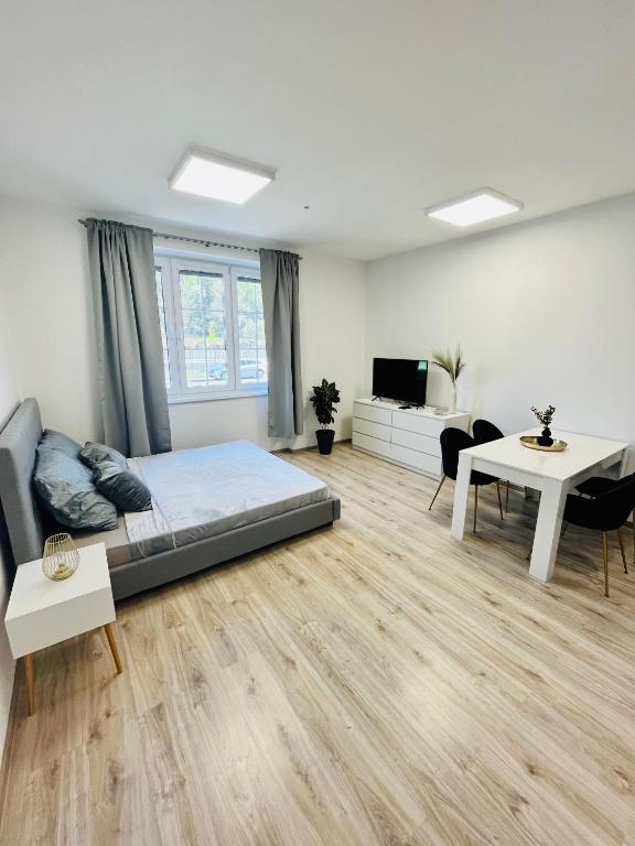 Großes weißes Zimmer mit einem Bett und einem Tisch in der Unterkunft Apartment Riviéra Centrum, private parking and smart check in in Banská Bystrica