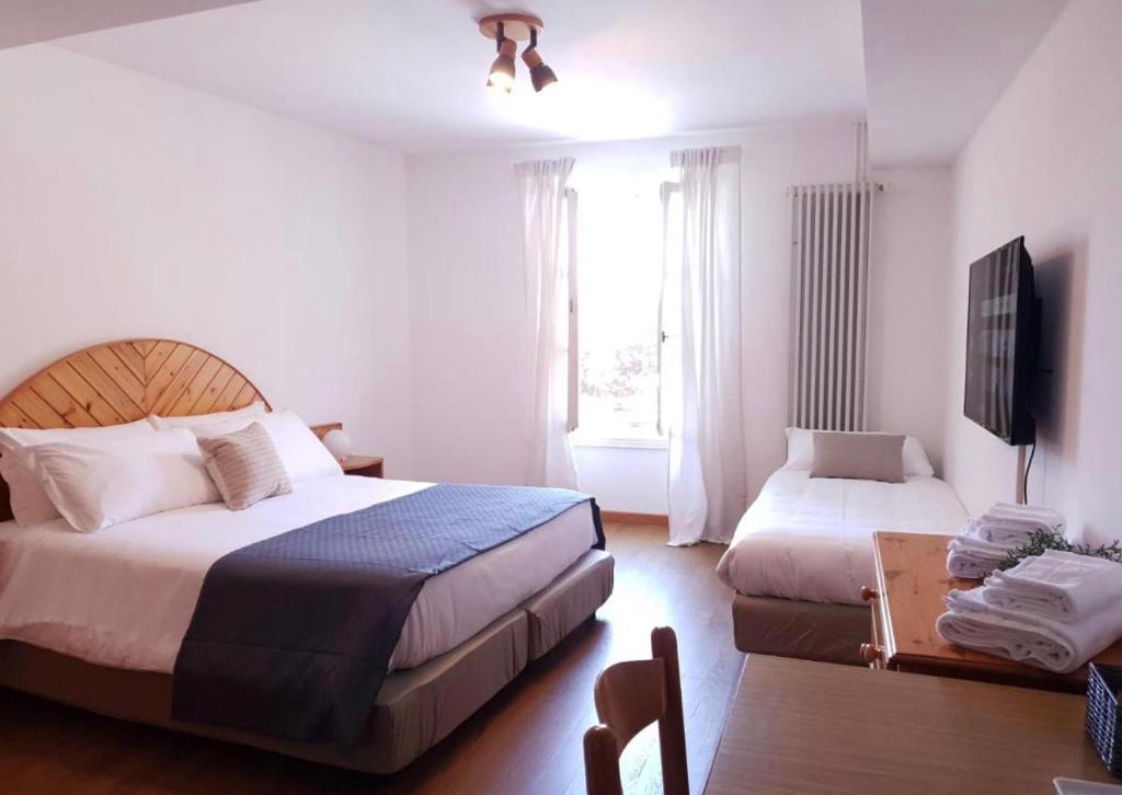 Habitación de hotel con 2 camas y TV en Val Colla B&B en Lugano