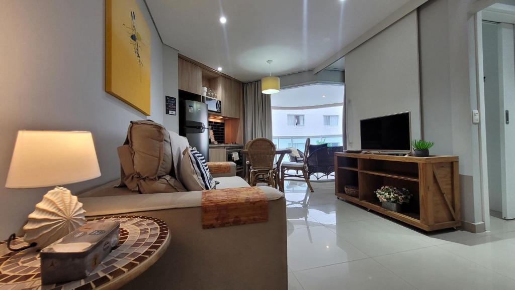 a living room with a couch and a television at Book Santos - Estanconfor 708 - 2 quartos in Santos