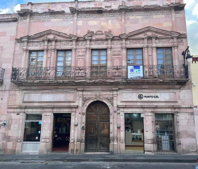 un gran edificio de ladrillo con un balcón en la parte superior. en Casona colonial en pleno centro histórico, en Zacatecas