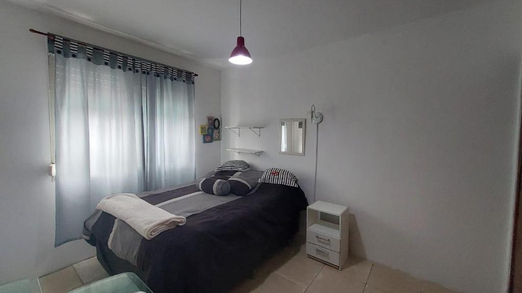 um quarto com uma cama e uma janela em La casa em Santana do Livramento