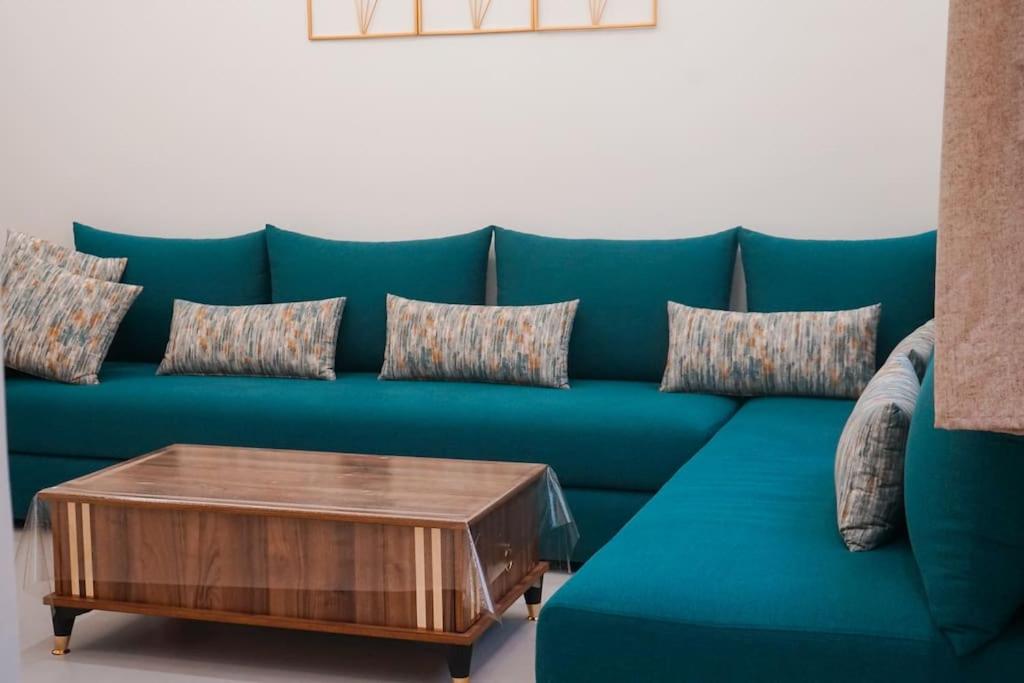 a blue couch with a coffee table in a living room at Appartement Chic et Luxueux Corniche Tanger in Tangier