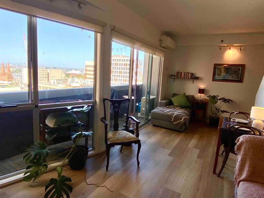 een woonkamer met uitzicht op de stad bij Cosy, Central Melbourne City Apartment in Melbourne