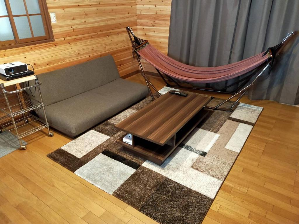 那须町小川のせせらぎを聞きながらウッドデッキでバーベキュー！｜CHILL SWING的客厅配有吊床和沙发