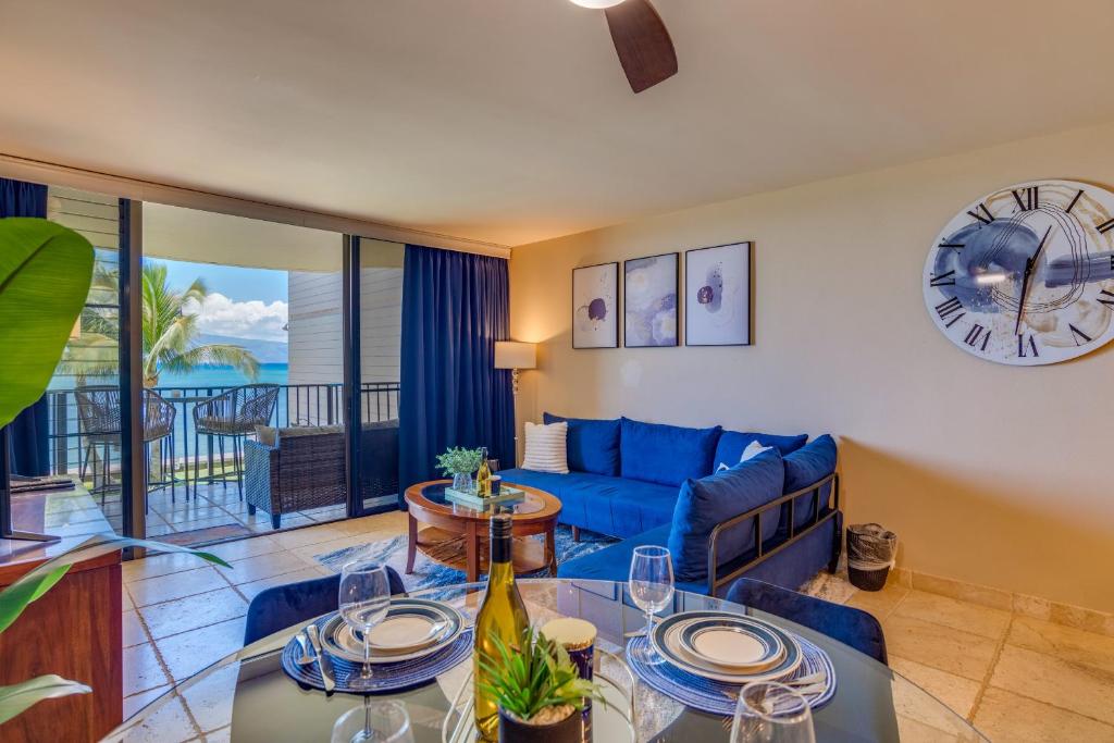 un salon avec un canapé bleu et une table dans l'établissement Kahana Reef #216, à Kahana