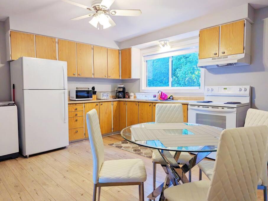 a kitchen with a table and a white refrigerator at Portsmouth Village Retreat in Kingston