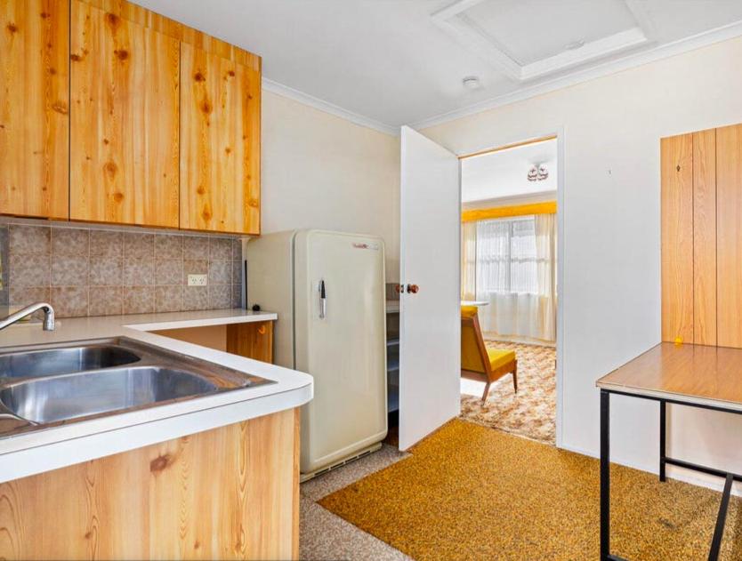 a kitchen with a sink and a refrigerator at The Vintage Flat - Retro Charm in Tyrolean Village in Jindabyne