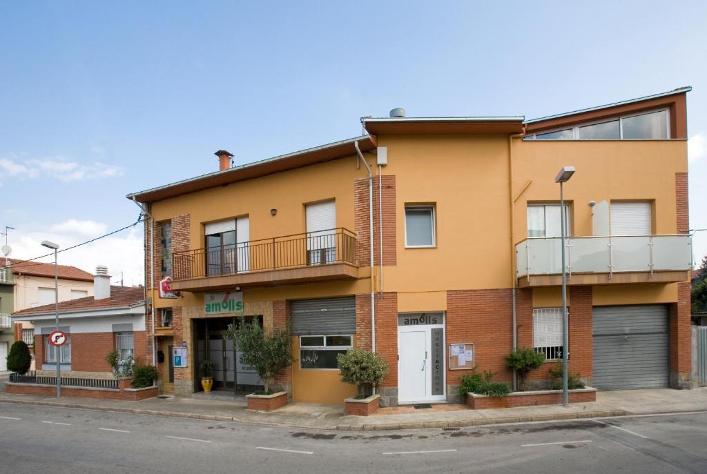 un immeuble situé dans une rue de la ville dans l'établissement Amolls Restaurant i Habitacions, à Olot