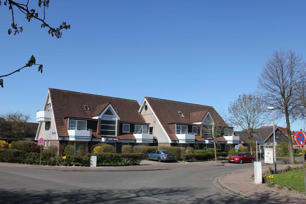 a row of houses with cars parked in a street at Apartmenthaus Padua in Büsum